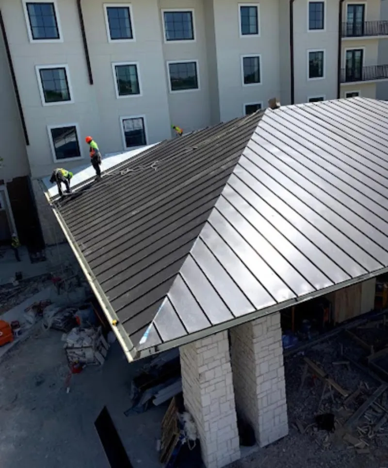 Crew installing standing seam metal roof panels on a commercial project in Golden Hills